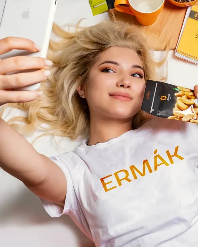 Девушка в футболке Ermak делает селфи со снеками
